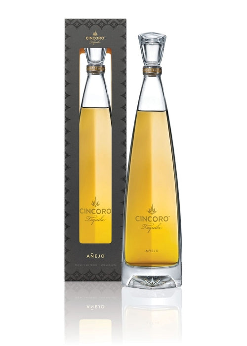 Cincoro Añejo tequila 700ml bottle with gold neck band and etched agave logo beside dark gray patterned box